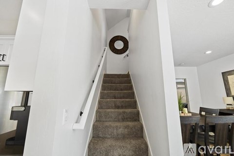 A staircase with a carpeted runner and a wooden banister.