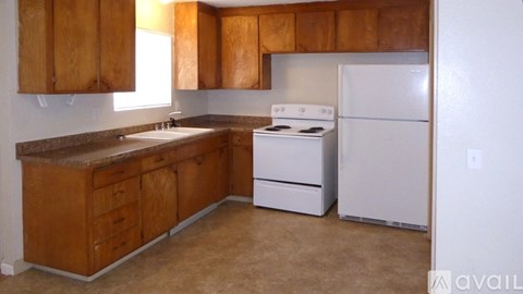 A kitchen with wooden cabinets and white appliances.
