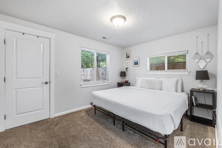 A bedroom with a bed, nightstand, and window.