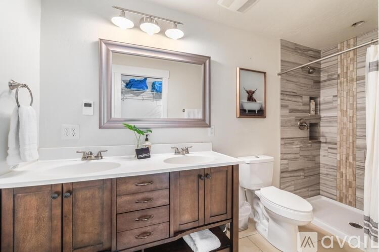 A bathroom with a wooden vanity and a large mirror.