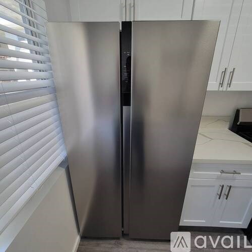 A stainless steel refrigerator in a kitchen.