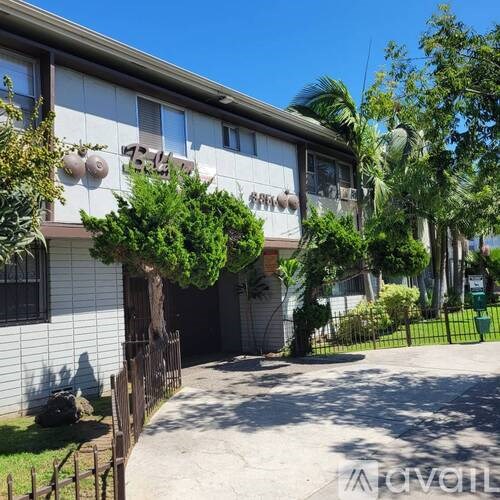 A white building with a brown fence in front of it.