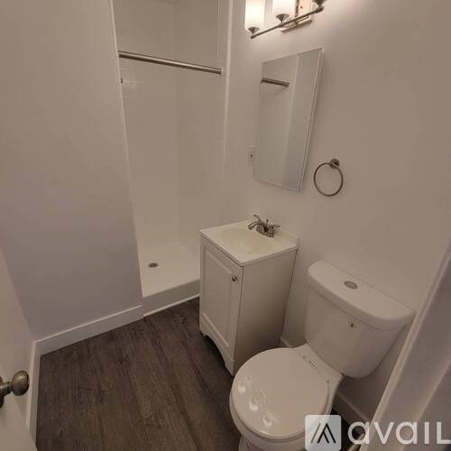 A white toilet sits next to a white cabinet in a small bathroom.