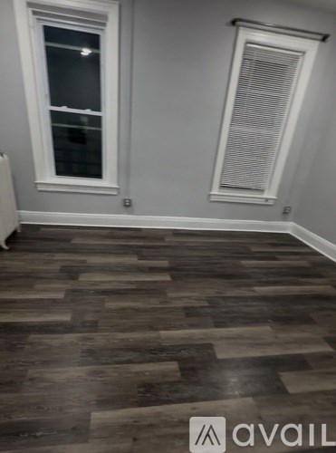 A room with a wooden floor and a window.