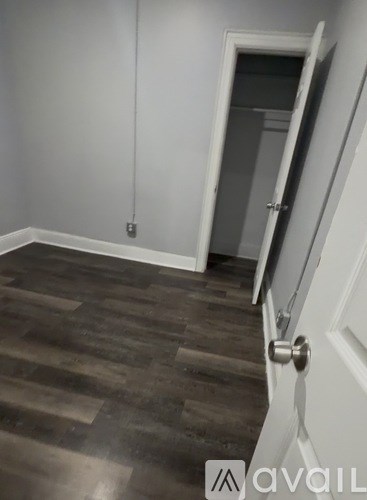 A room with a wooden floor and a white door.