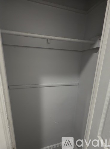 A white closet with a shelf and a hanger.