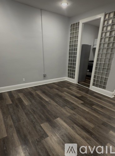 A room with wooden flooring and a wall of windows.