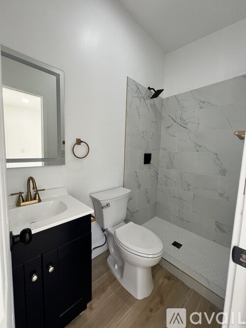 A bathroom with a white toilet and a sink with a black cabinet.