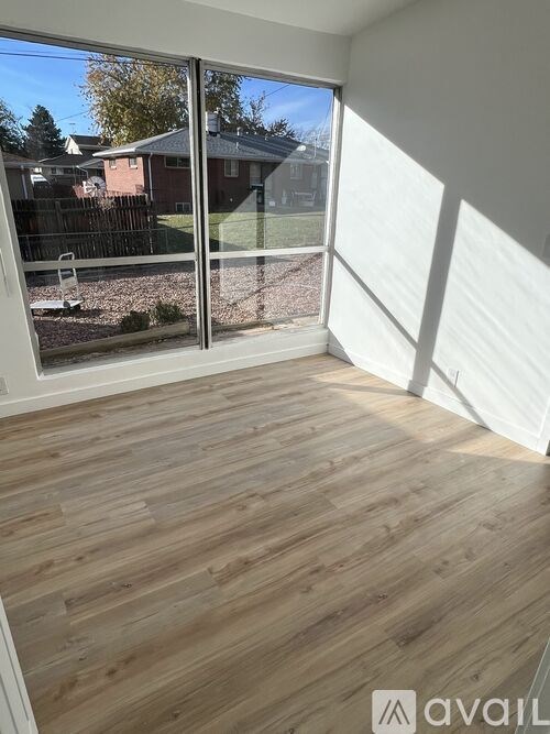 A room with wooden flooring and a sliding glass door.