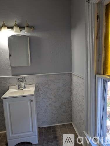 A bathroom with a white sink and a mirror.