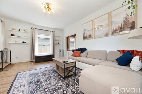 A living room with a beige sofa, a coffee table, and a rug.