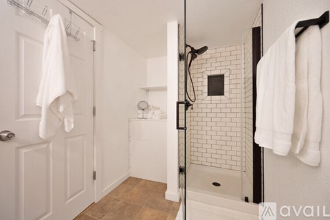 A bathroom with a white door and a white shower.