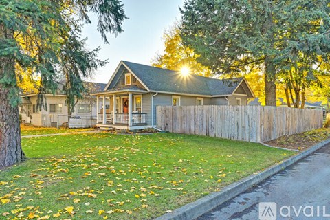 A house with a fence and trees in front of it.