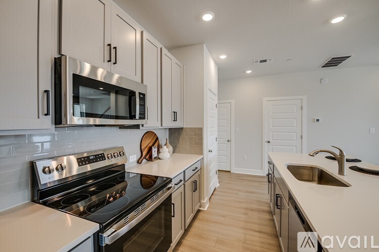 A modern kitchen with a stove, microwave, and oven.