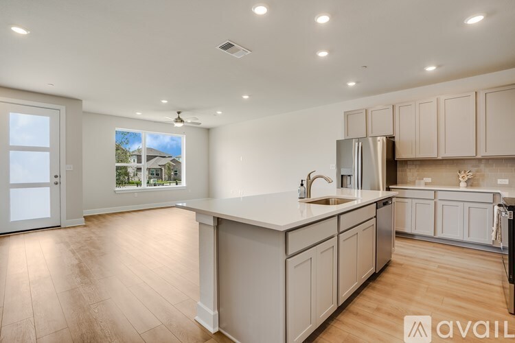 A kitchen with wooden floors and white cabinets is available for rent.