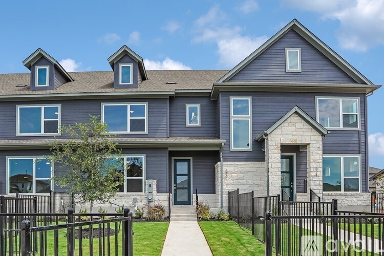 A house with a grey front and a black fence.