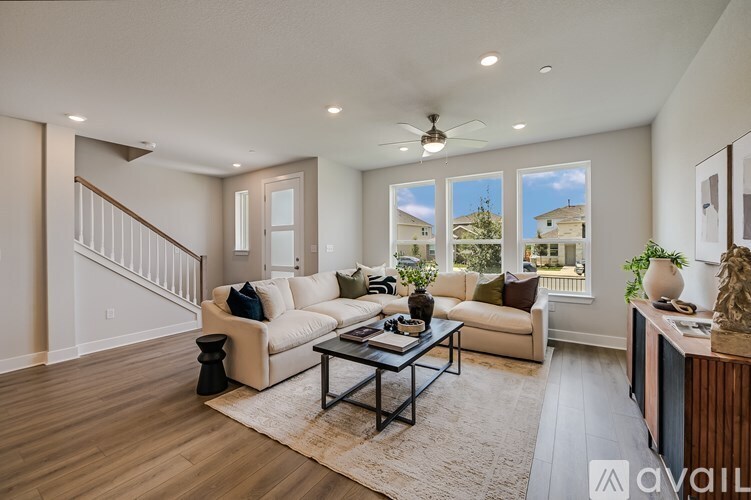 A living room with a white couch, a coffee table, and a ceiling fan.
