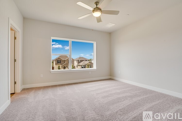 A room with a carpeted floor and a ceiling fan.