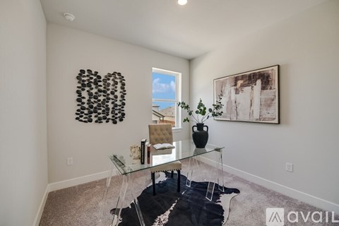 A living room with a glass table and a black cowhide rug.