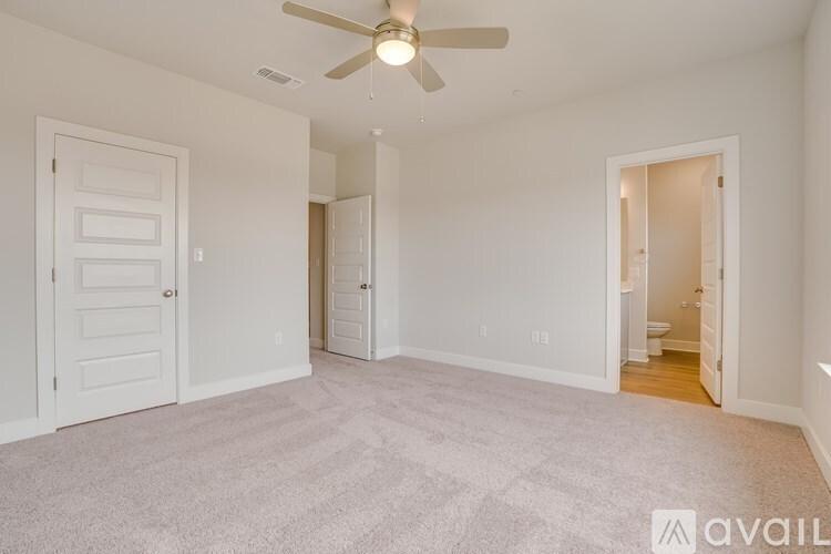 A room with a carpeted floor and a ceiling fan.