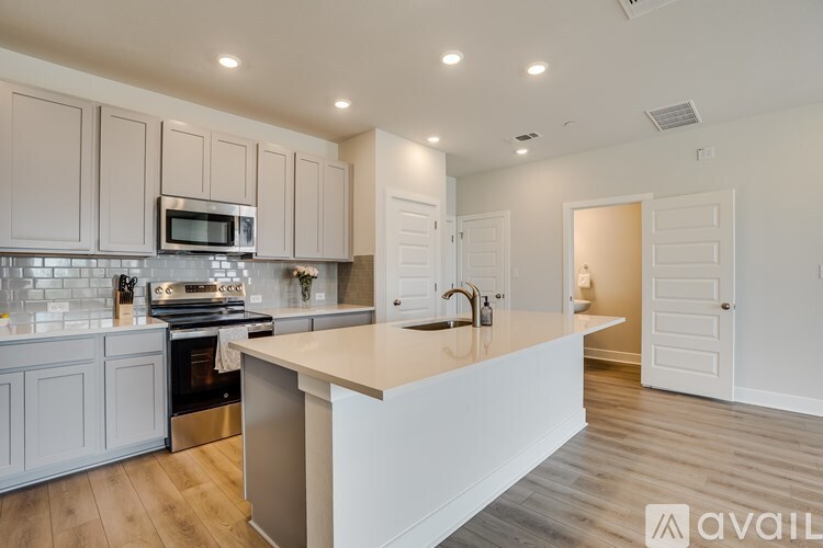 A kitchen with a white countertop and cabinets.