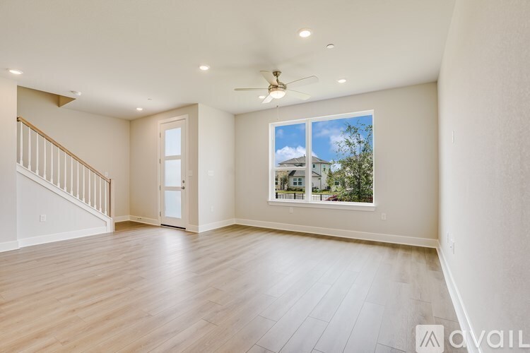 A spacious room with a window overlooking a residential area.