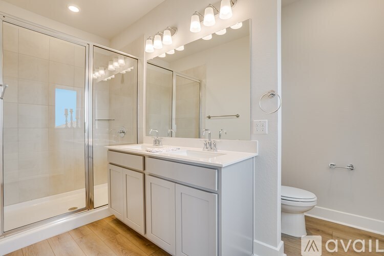 A bathroom with a white sink and a glass shower door.
