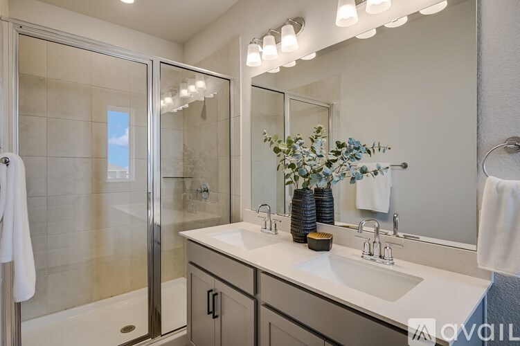 A modern bathroom with a white countertop and a large mirror above it.