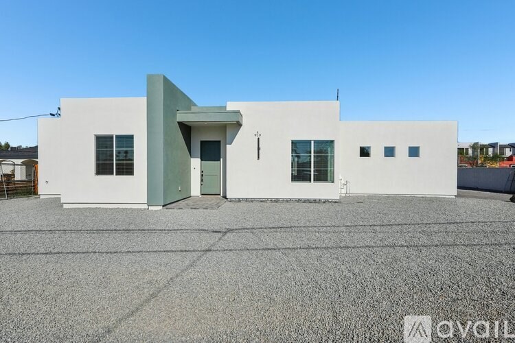 A white building with a green door and windows.