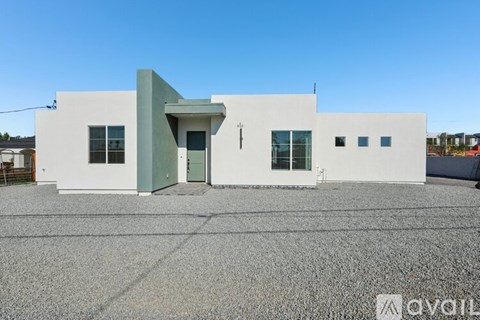 A white building with a green door and windows.