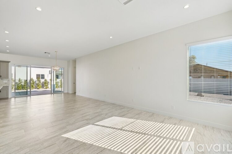 A spacious room with a large window and a view of a building outside.