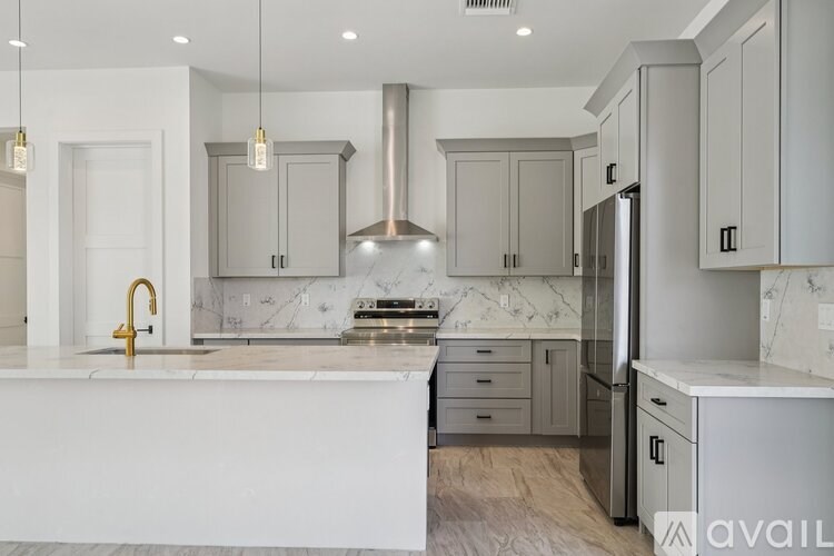 A modern kitchen with a marble backsplash and stainless steel appliances.