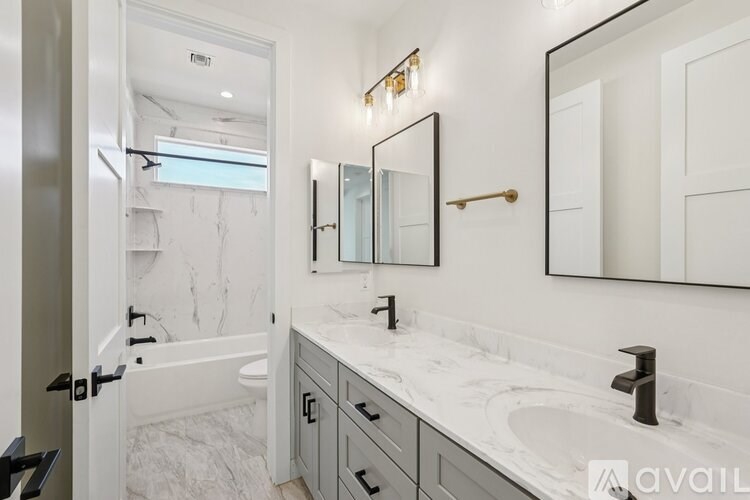 A bathroom with a marble countertop and a large mirror above the sink.