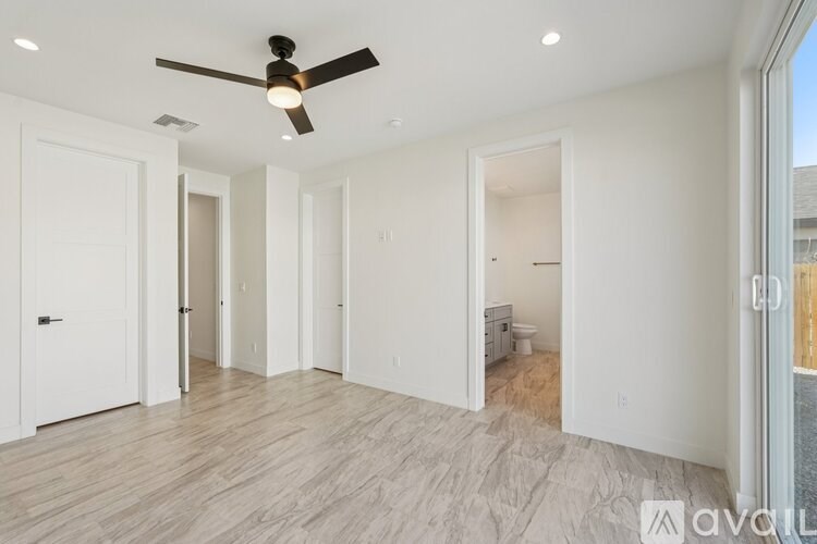 A spacious room with a ceiling fan and lighting fixtures.