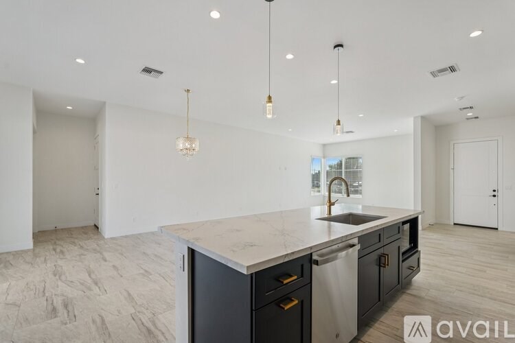 A modern kitchen with a marble countertop and stainless steel appliances.
