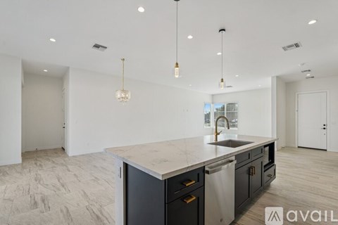 A modern kitchen with a marble countertop and stainless steel appliances.