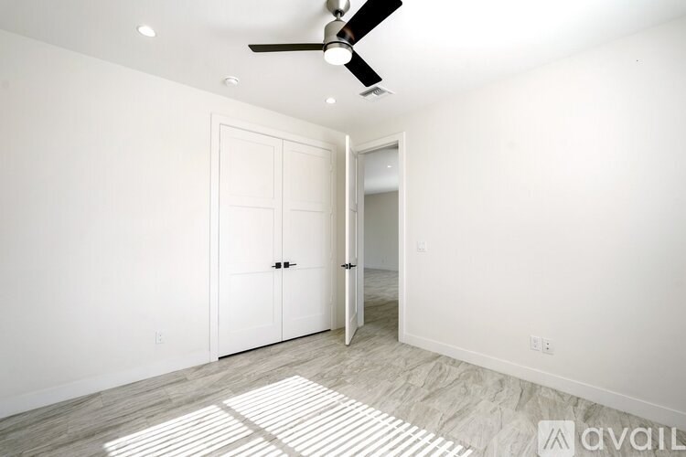 A room with a ceiling fan and two doors.