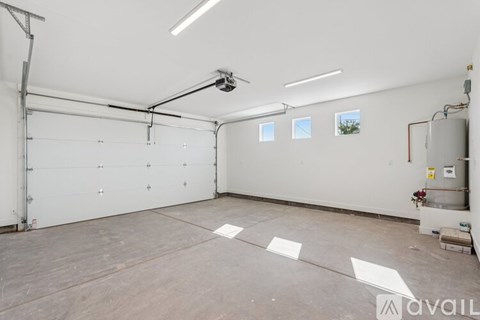 A large, empty garage with a white ceiling and a window on the wall.