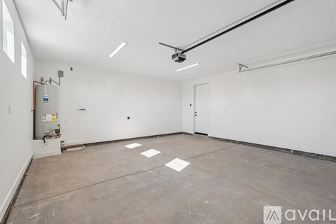 A large empty room with a fan on the ceiling and a door on the right side.