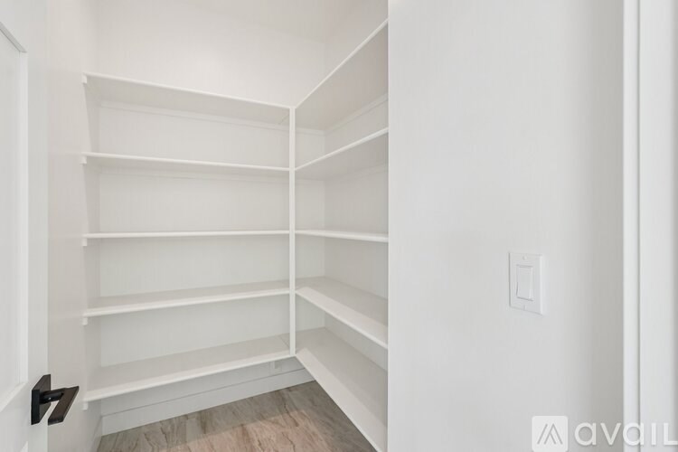 A white closet with shelves and a door.
