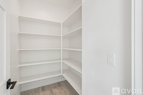 A white closet with shelves and a door.