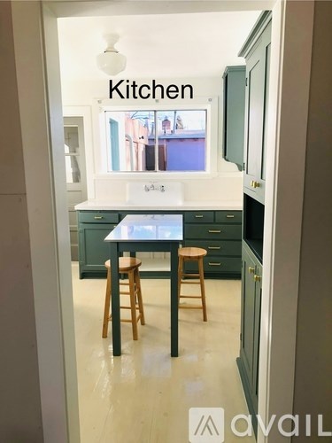 A kitchen with a table and two stools.