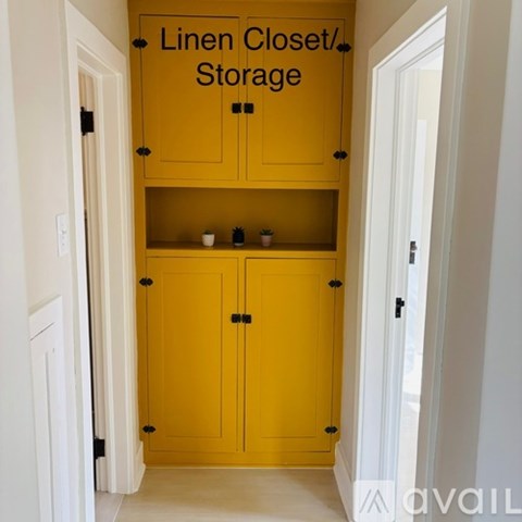 A yellow linen closet/storage cabinet with two doors and two shelves.