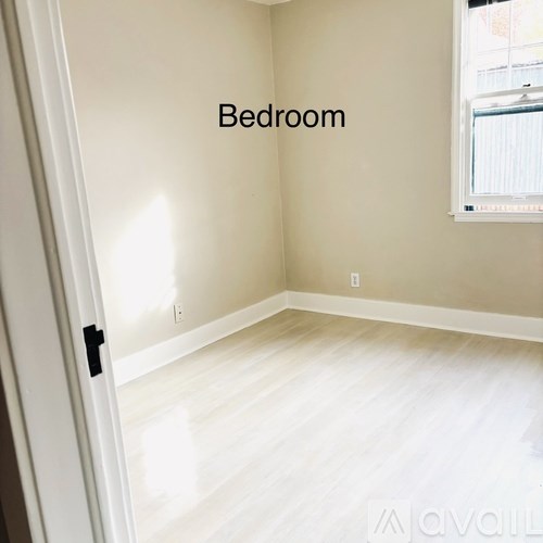 A bedroom with a door and a window.