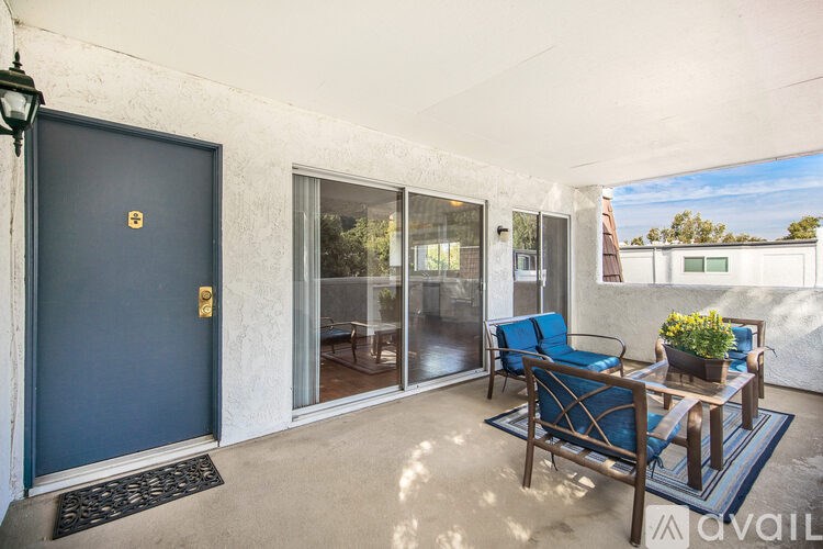 A patio with a blue door and a table with chairs.