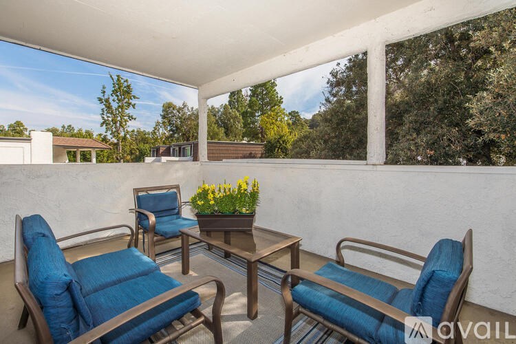 A patio with a table and chairs with blue cushions.