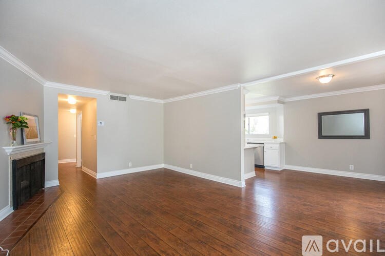 A spacious living room with hardwood floors and a fireplace.