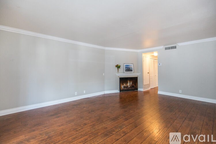 A room with a fireplace and wooden floors.