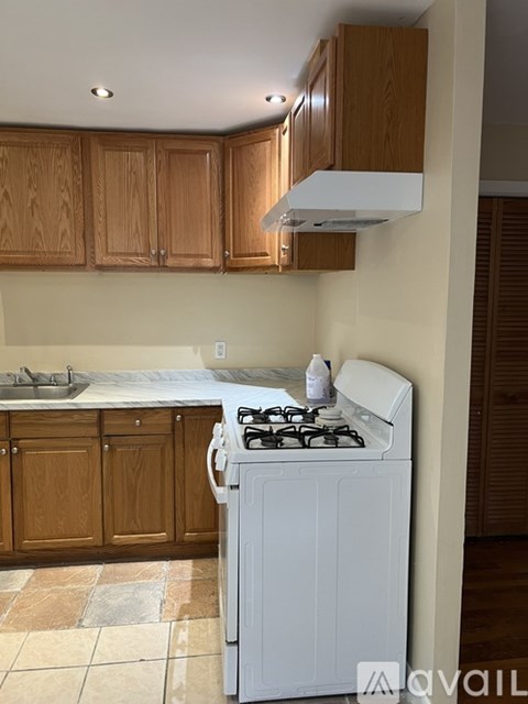 A kitchen with a white stove and wooden cabinets.