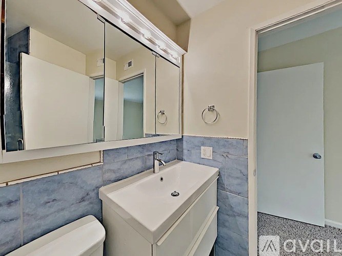A white sink in a bathroom with a mirror above it.